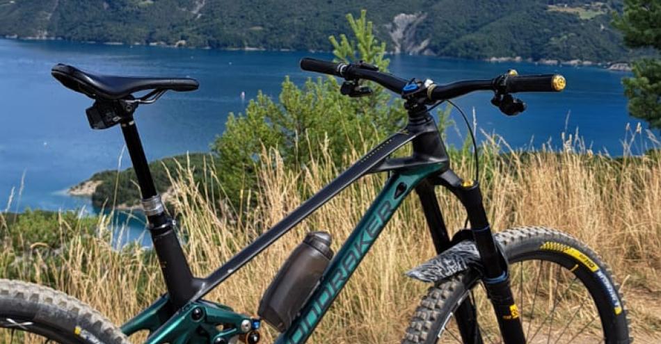 photo représentant un vélo avec vue plongeante sur le lac de Serre Ponçon.